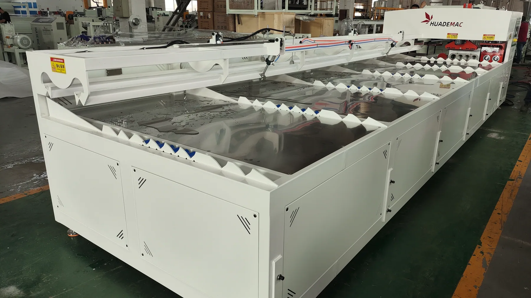 Top view of automatic pipe belling machine with multiple pipe conveying lanes