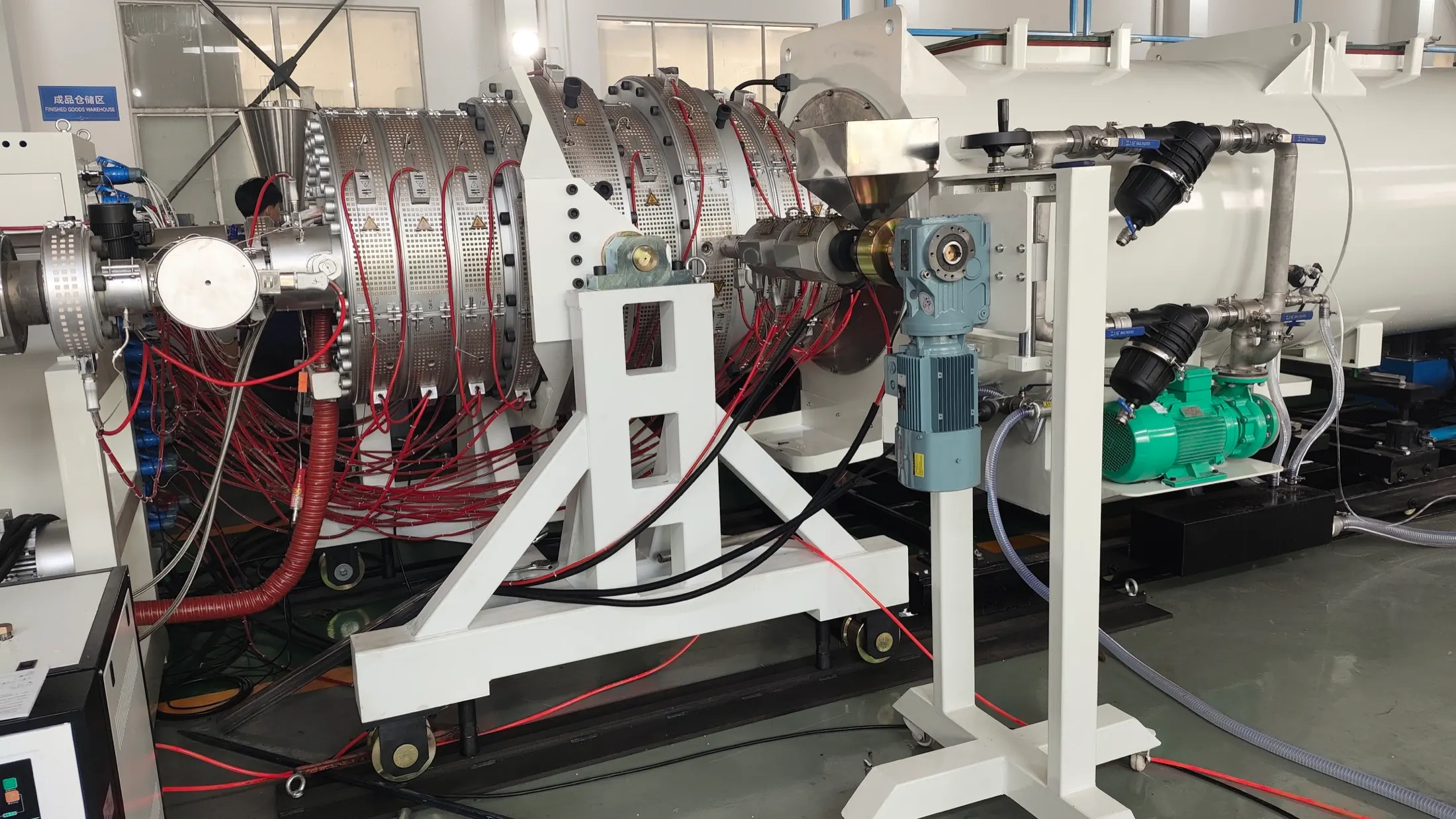 Close-up of HDPE pipe extrusion die head and calibration tooling