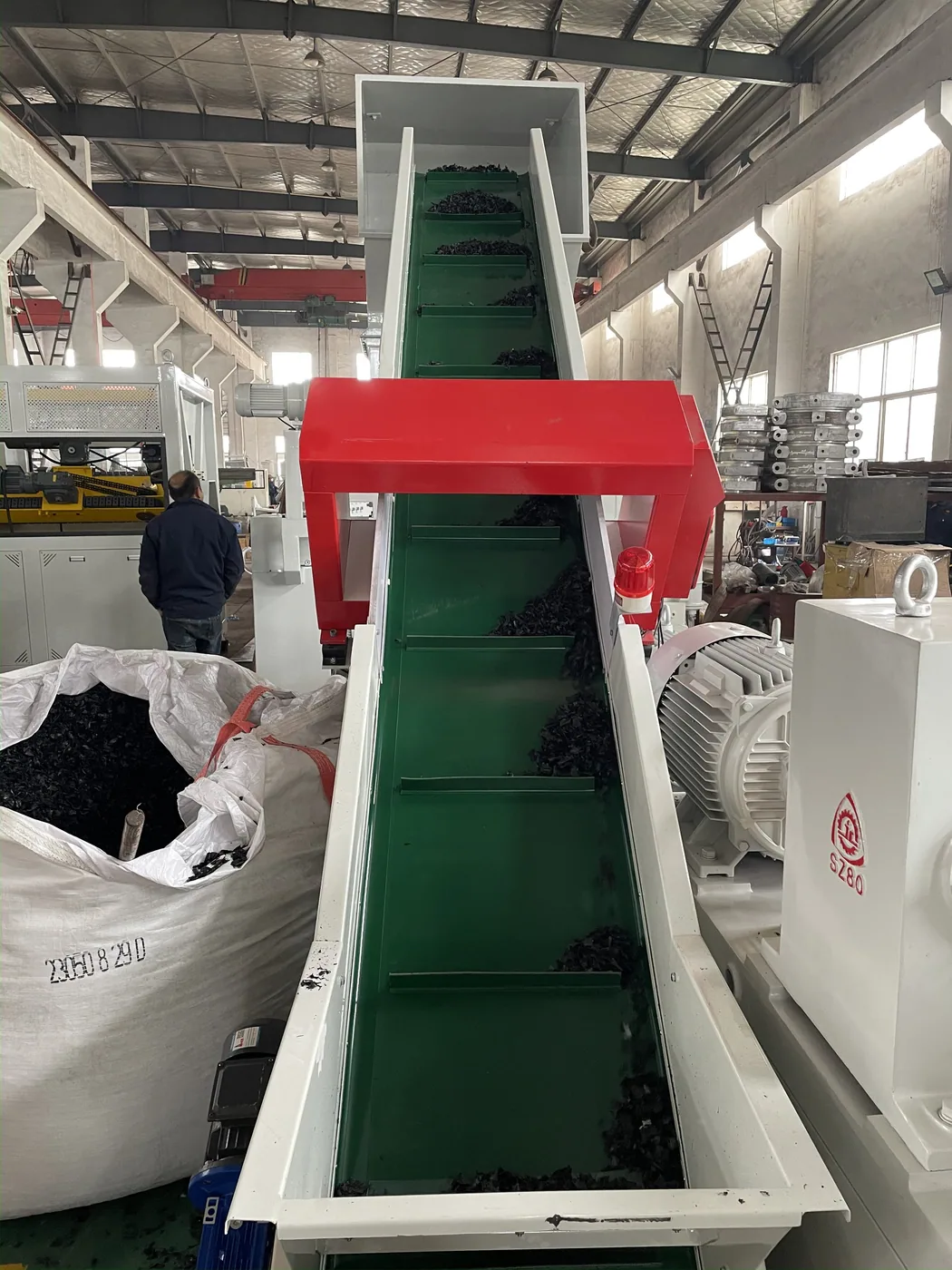 Belt conveyor feeding PE PP waste film into the recycling pelletizing line