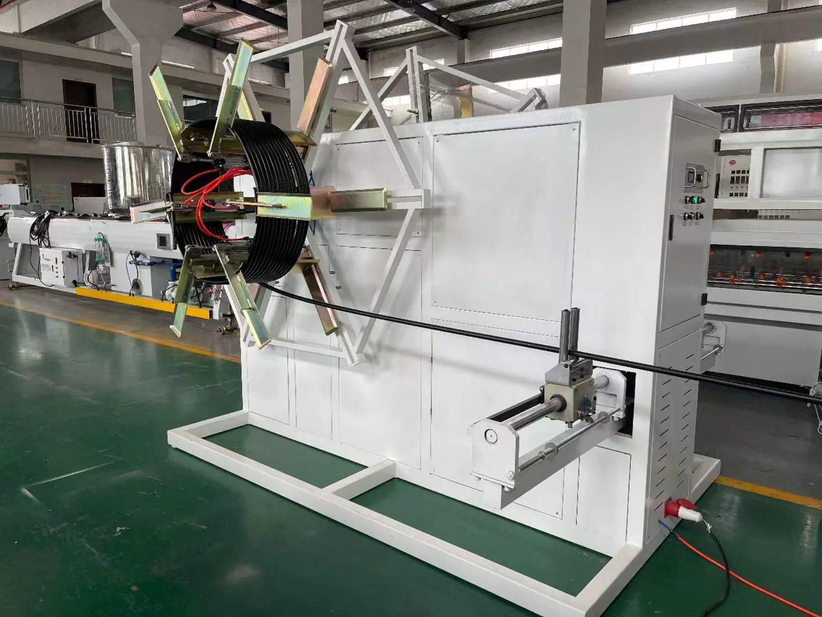 Single disc pipe winder side view beside extrusion line